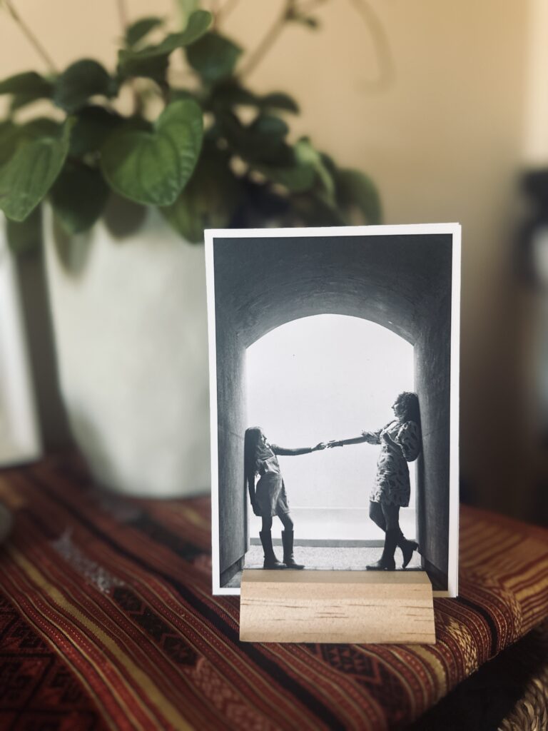 wood black and photo print display stand.  Photo product is displayed in home on a dresser with a plant in background.