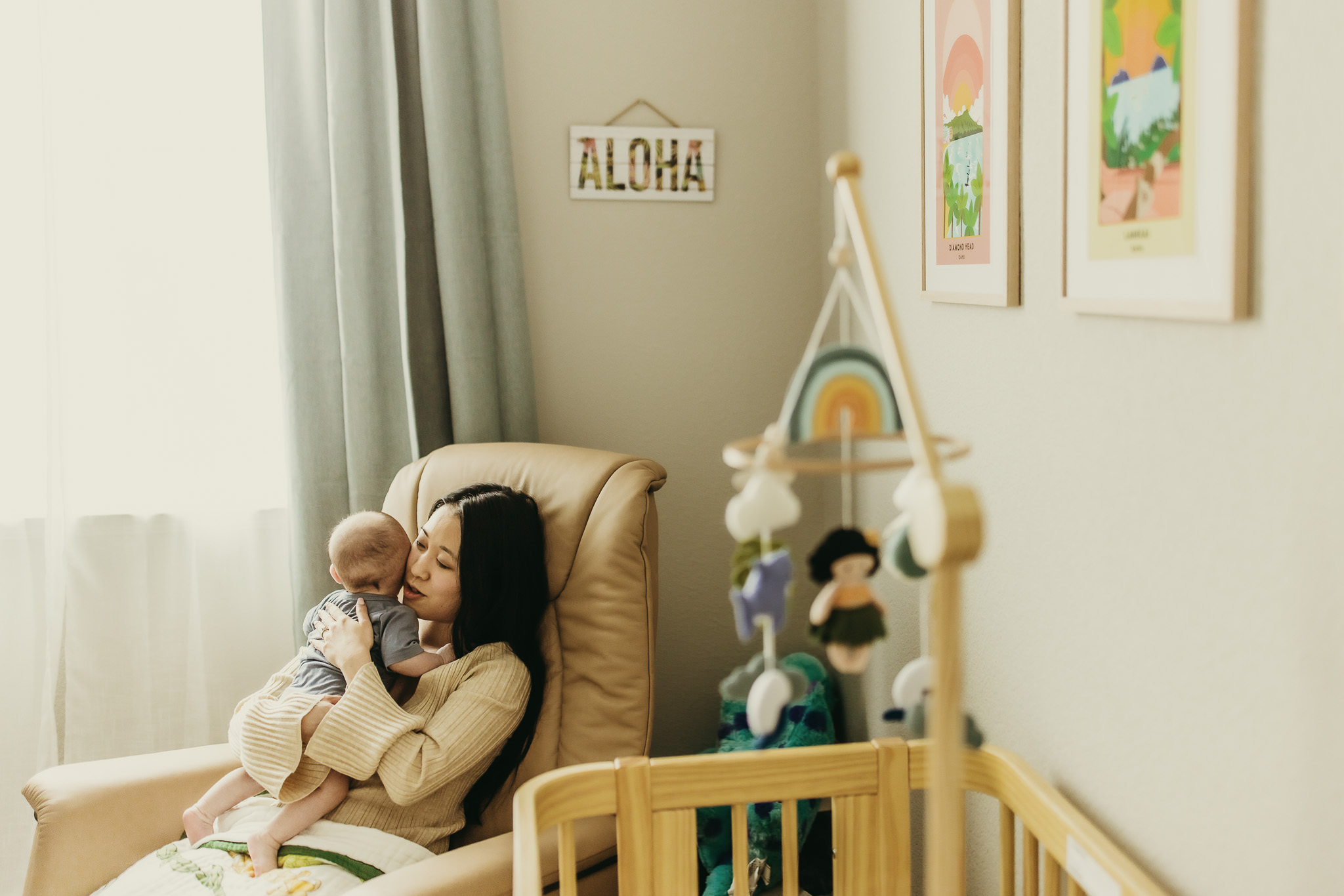 mom rocking newborn baby at in home lifestyle newborn session with Ashley Kaplan Photography