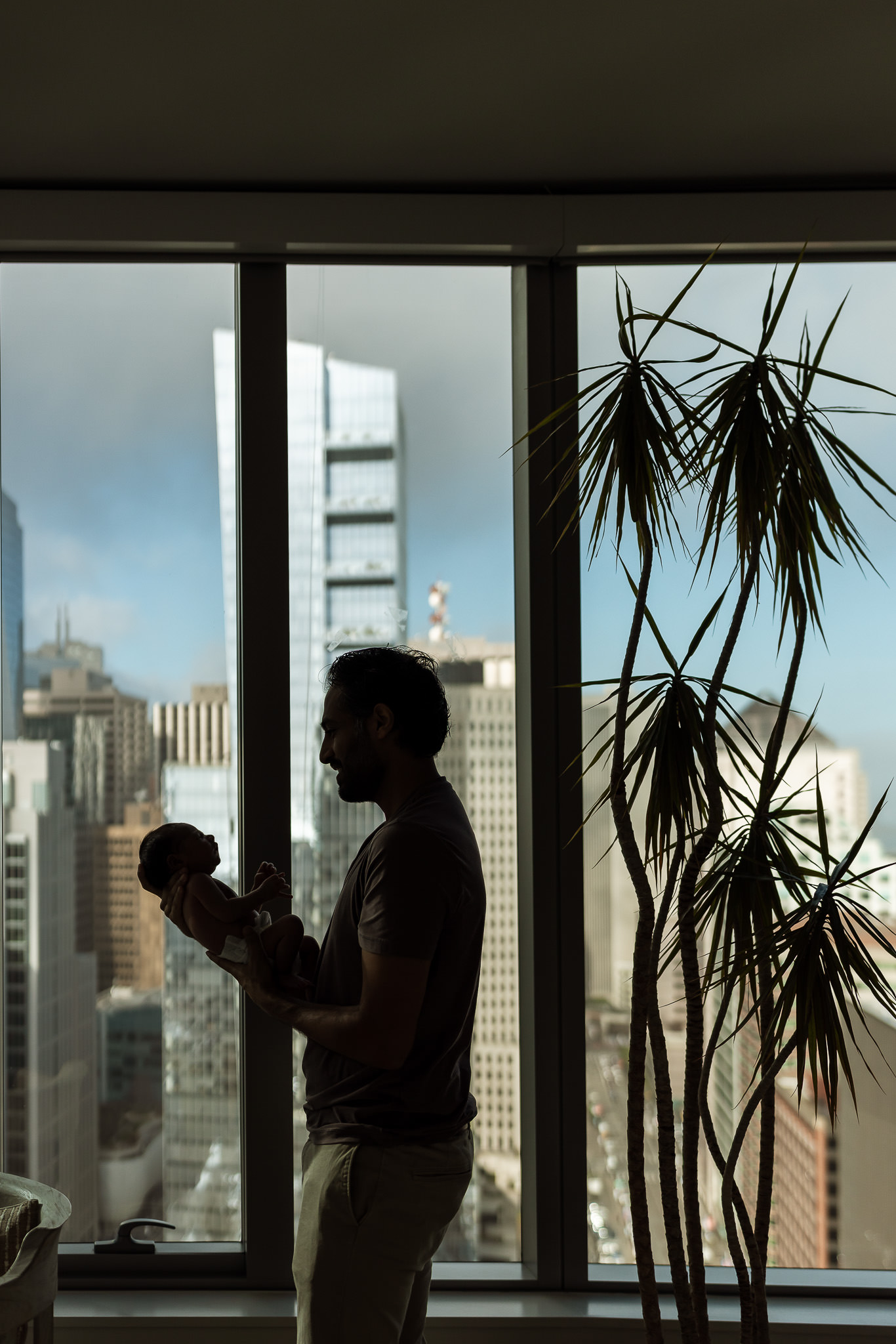 Artistic silouehette of dad and baby at in home lifestyle newborn session with Ashley Kaplan Photography