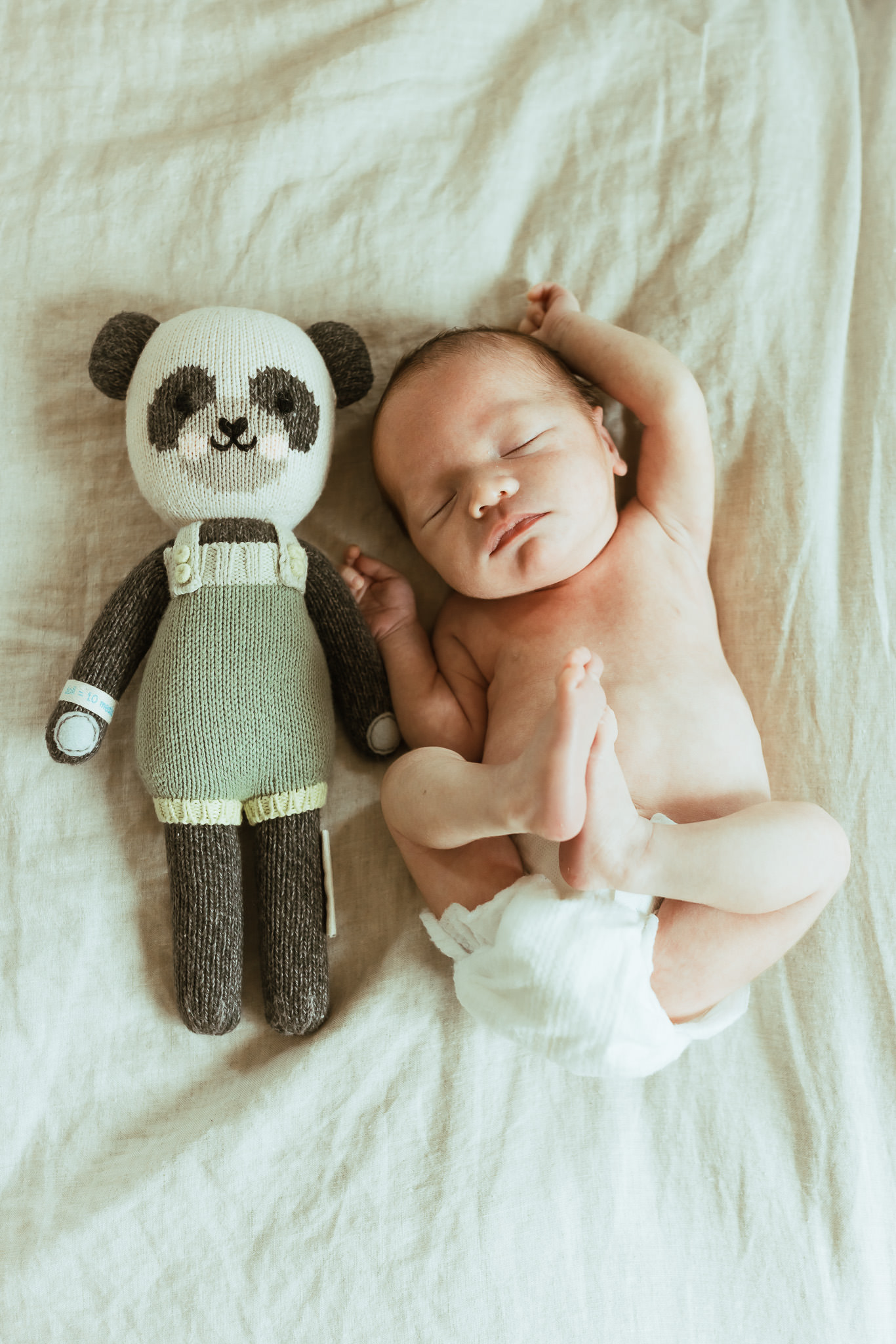 baby cuddled with stuffed animal at in home lifestyle newborn session with Ashley Kaplan Photography