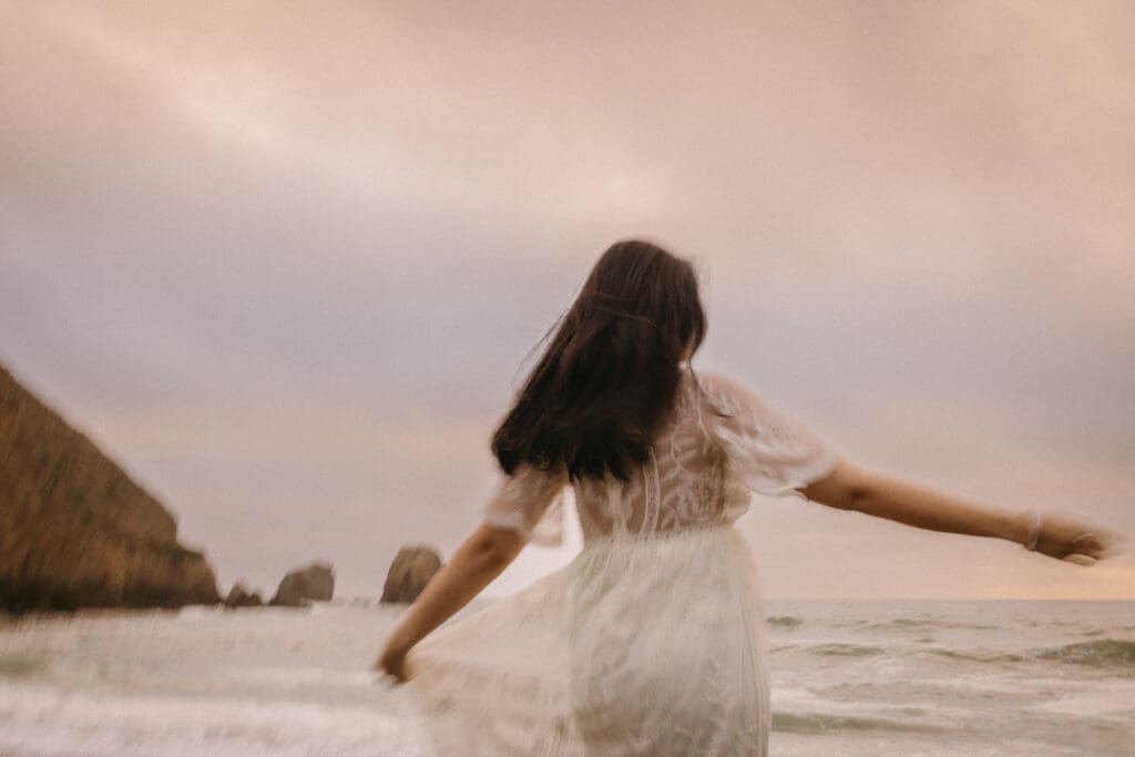 Woman spinning and free on beach. Creative photo with motion blur.